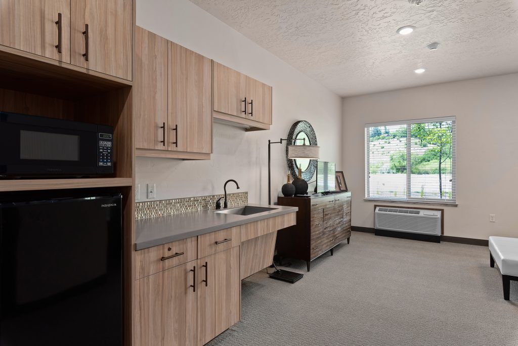A modern kitchen with wooden cabinets and a large window.