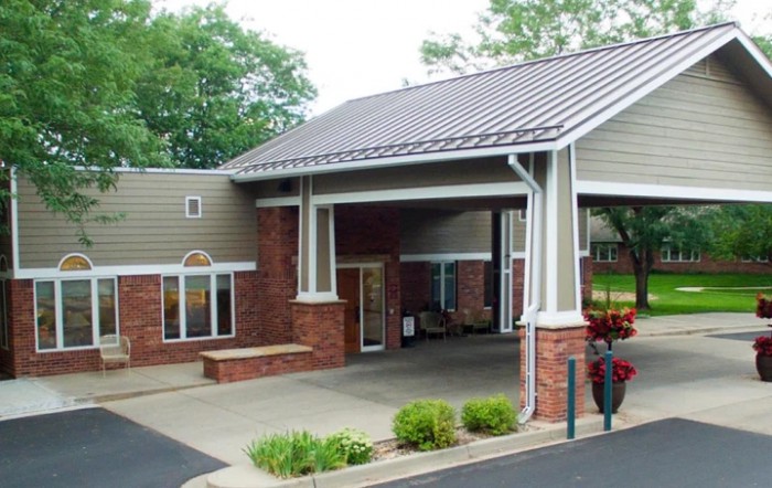 A small building with a covered entrance and brick exterior.