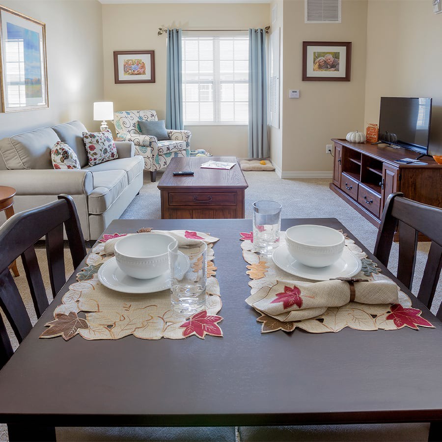 A cozy living room with a neatly set dining table and comfortable furnishings.