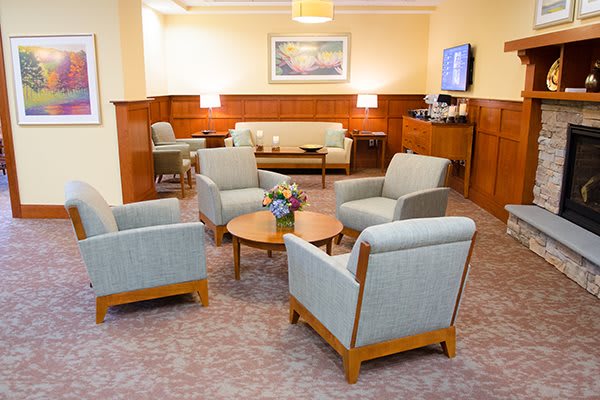 A comfortable waiting room with armchairs and a sofa arranged around a wooden coffee table.