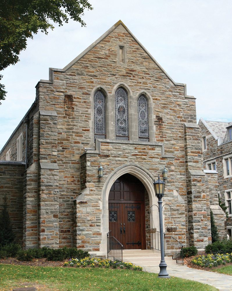 A stone church featuring gothic architecture and stained glass windows.