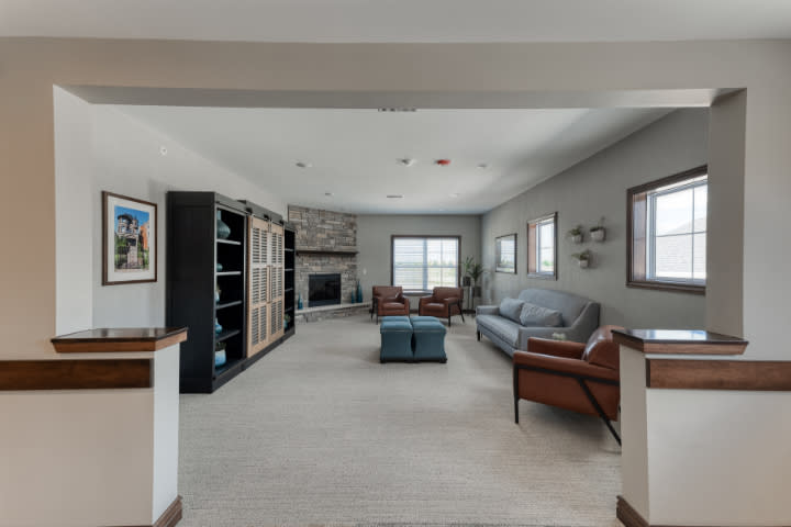 A spacious living room with a modern design featuring a fireplace, comfortable seating, and large windows.