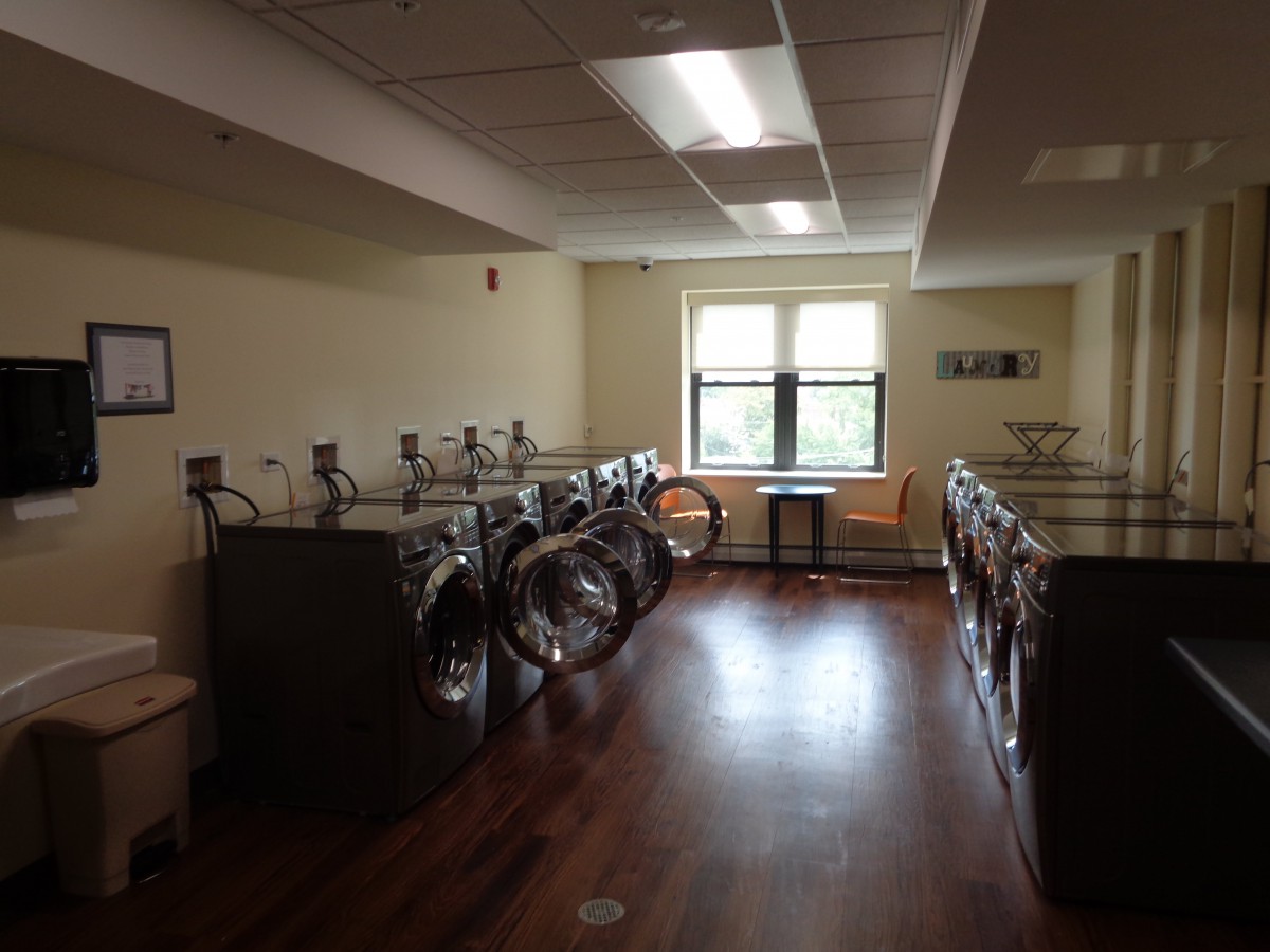 A spacious laundry room with multiple washing machines and dryers.