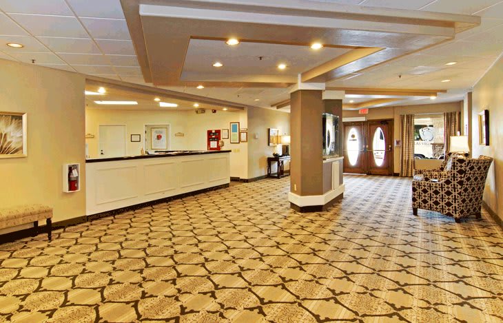 A spacious hotel lobby with a reception desk and decorative lighting.