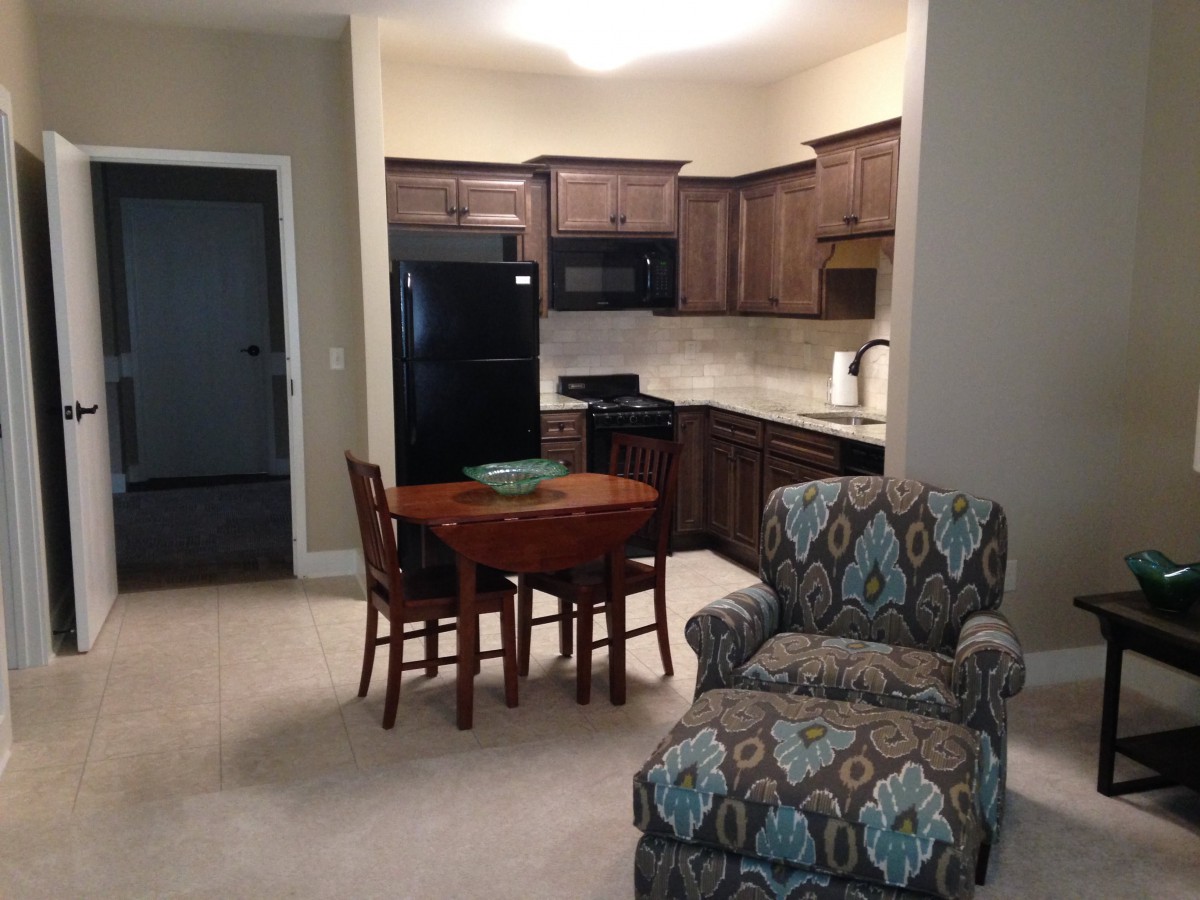 A cozy apartment interior featuring a compact kitchen and dining area.