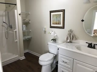 A modern bathroom with a toilet, sink, and shower.
