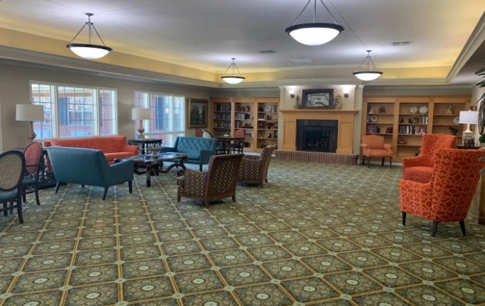 A spacious living room with colorful seating and a fireplace.