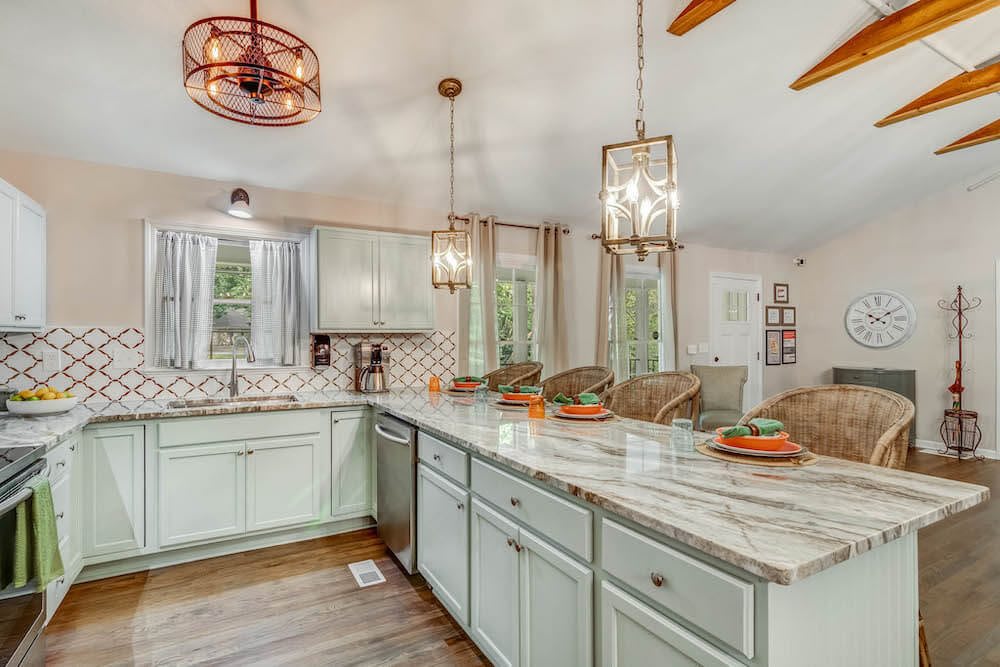 A modern kitchen with an open layout, featuring elegant pendant lighting and a spacious countertop.