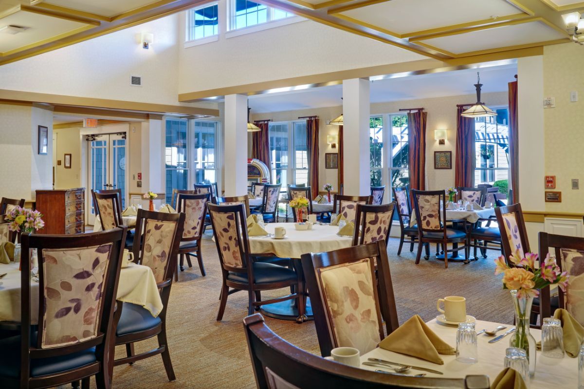 A spacious and elegantly decorated dining room with neatly arranged tables and chairs.