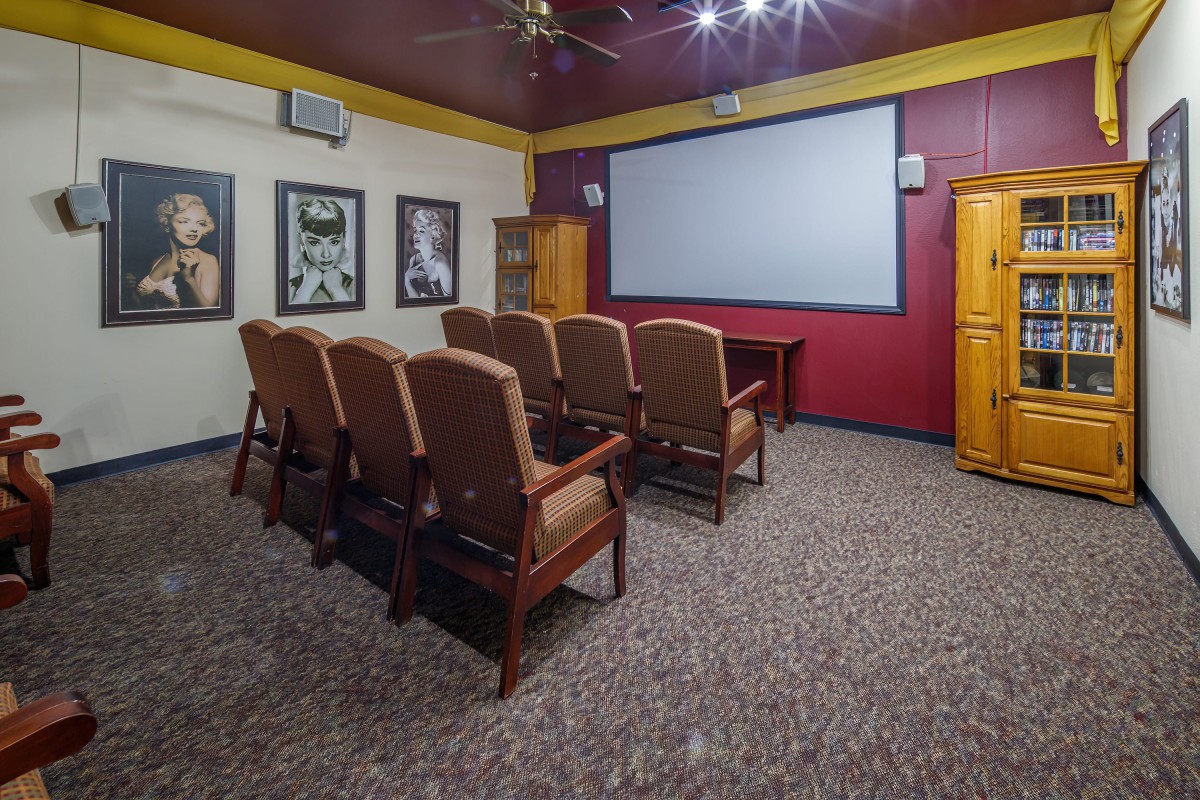 A cozy home theater room featuring rows of seating and a large screen for movie viewing.