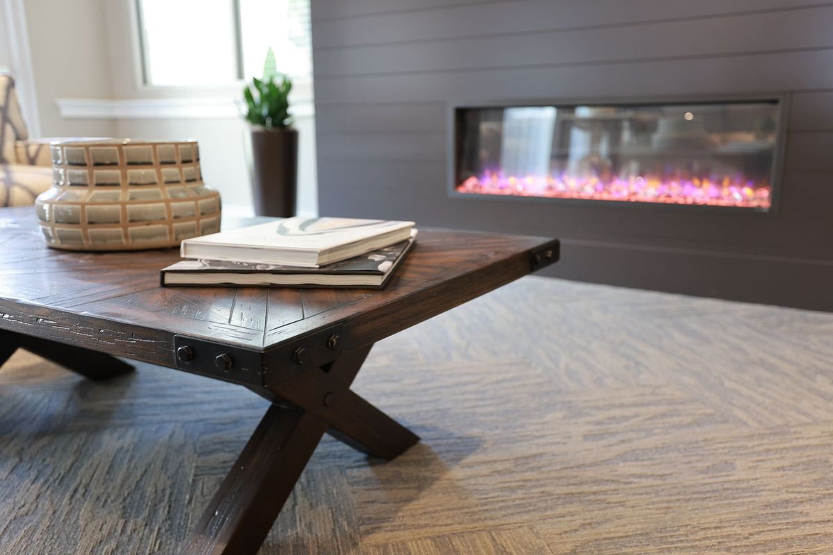 A cozy living room with a modern coffee table and fireplace.