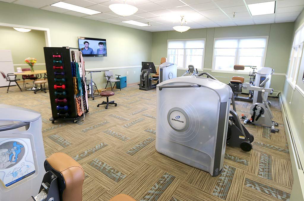 A well-equipped physical therapy and rehabilitation room with exercise machines and weights.