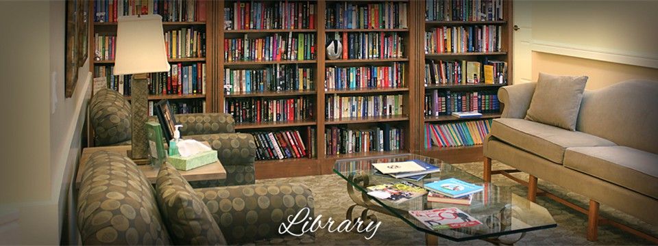A cozy library with shelves filled with colorful books and comfortable seating.