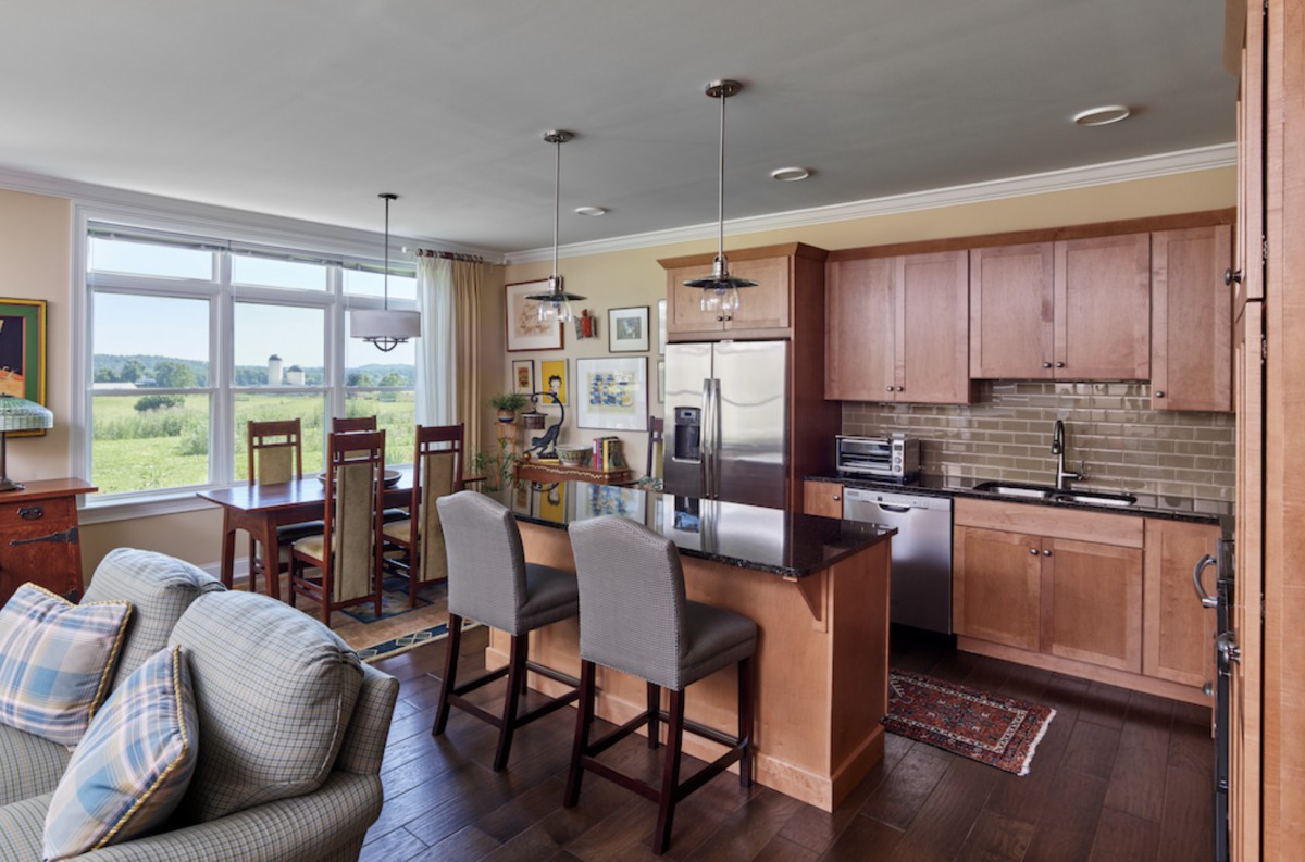 Contemporary kitchen and dining area with an open floor plan, featuring modern decor and stainless steel appliances.