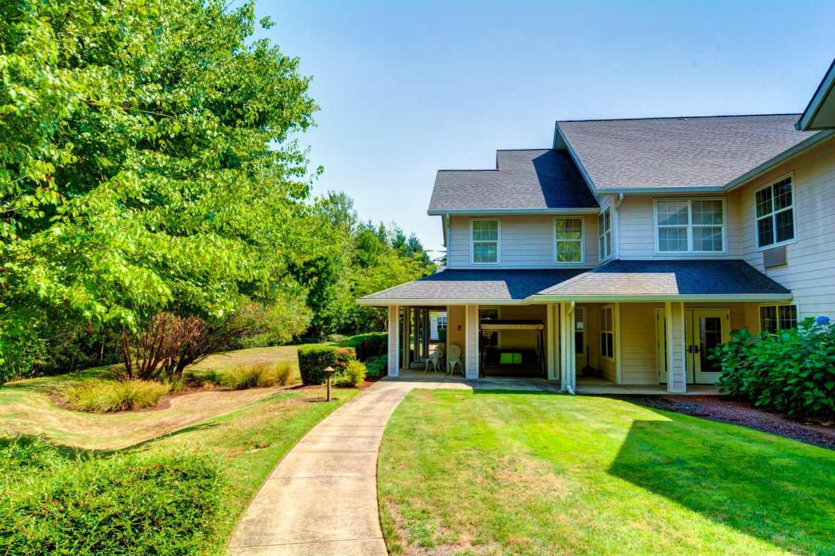 A charming suburban house with a well-maintained lawn and pathway.
