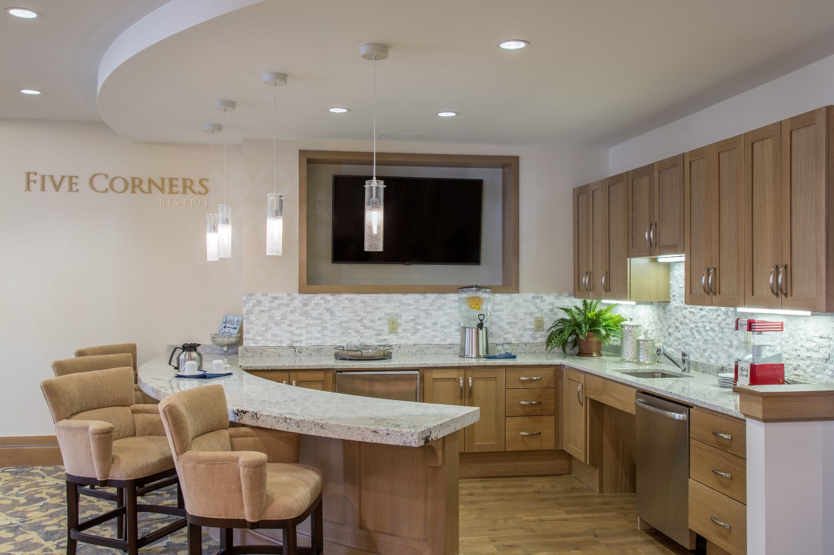 A modern kitchen interior with wooden cabinets and stylish lighting.