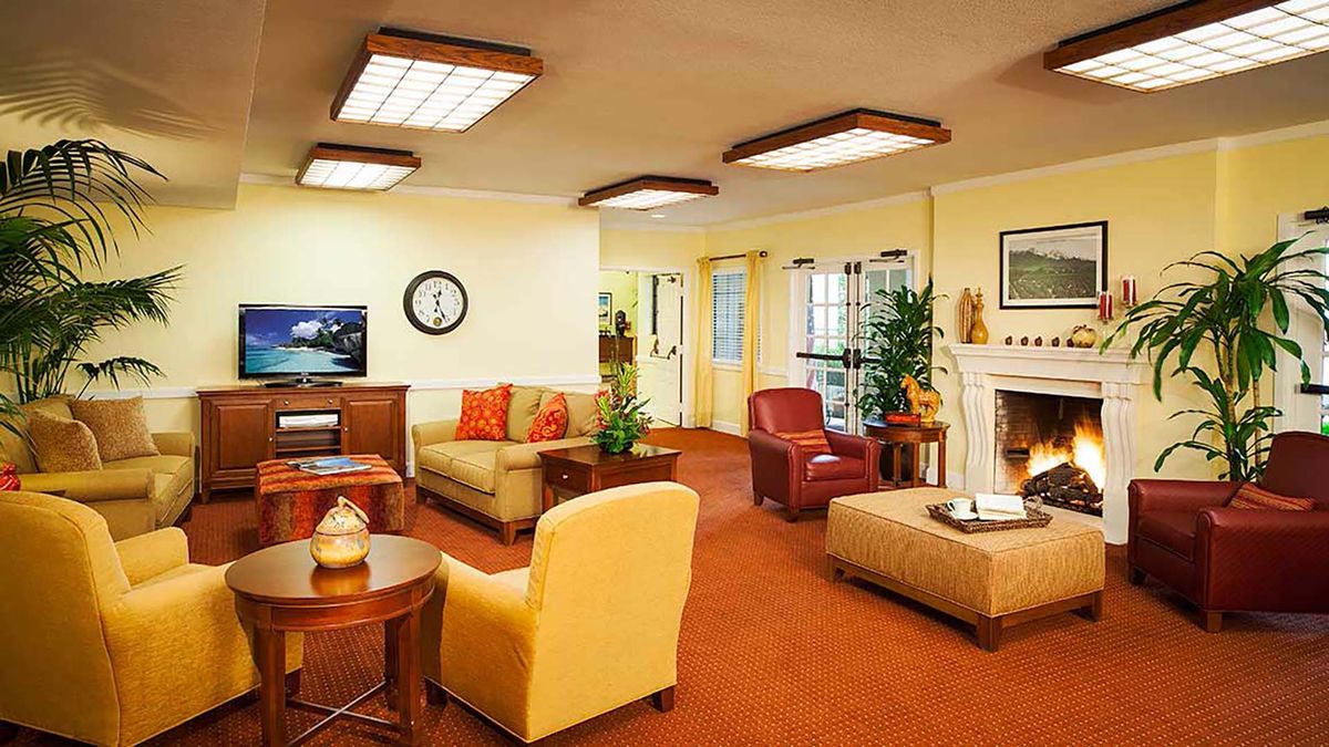 A cozy and well-decorated living room featuring comfortable seating, a fireplace, and modern lighting.
