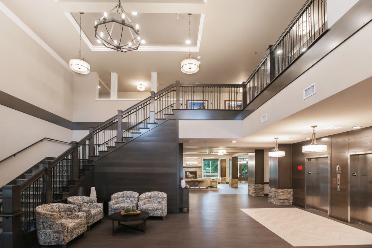 A spacious and modern lobby with a grand staircase and elegant lighting.