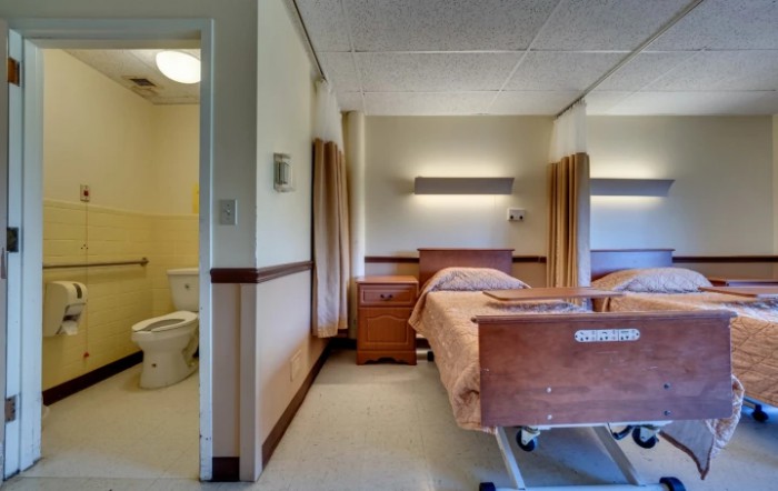 A clean and organized hospital room with patient beds and dividing curtains.