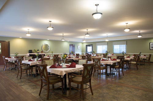 A spacious and inviting dining area with neatly arranged tables and warm lighting.
