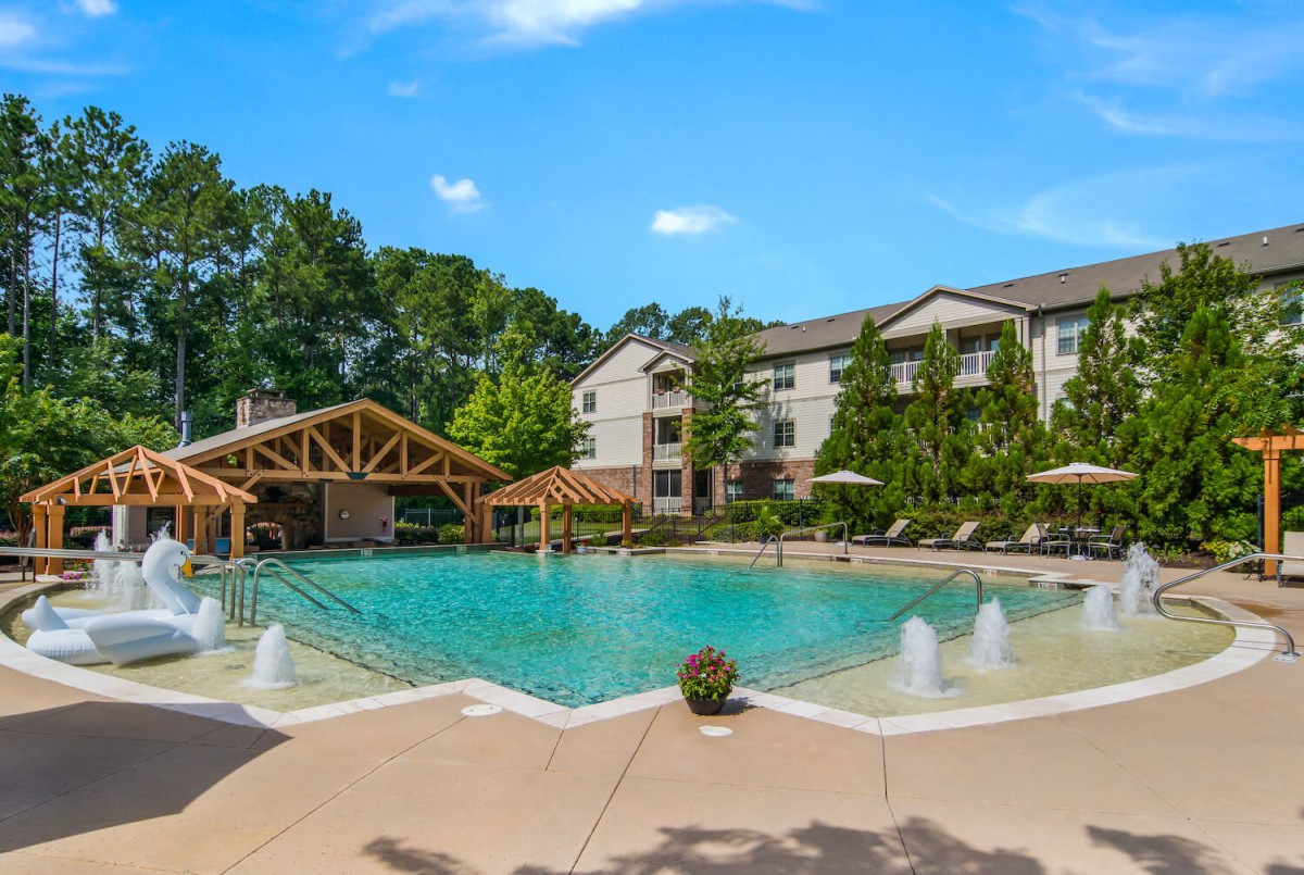 A beautiful outdoor swimming pool area at a resort on a sunny day.