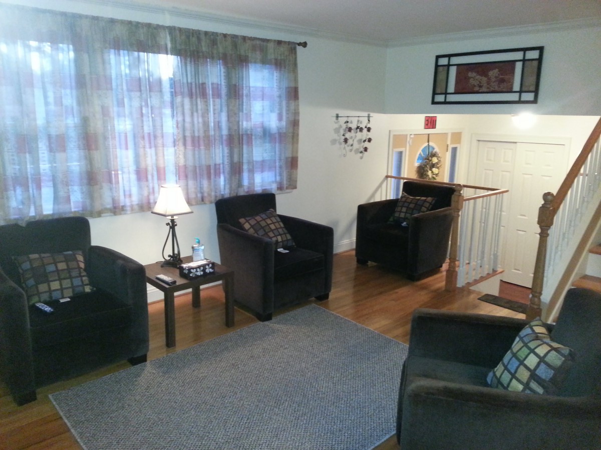 A cozy living room with chairs, a table, and a lamp.