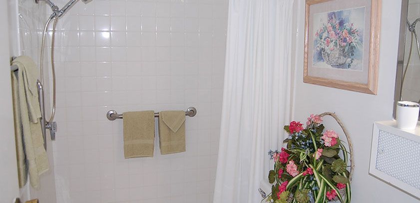 A neatly arranged bathroom with towels and floral decor.