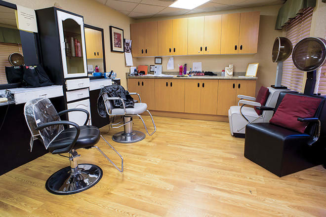 A cozy hair salon with modern barber chairs and mirrors.