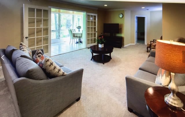 A cozy living room with modern furniture and large windows.