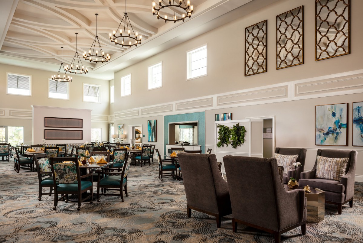 A bright and spacious modern dining area with elegant chandeliers and comfortable seating.