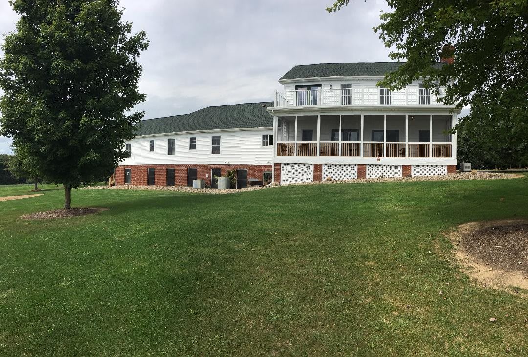 A large residential house with a spacious lawn.