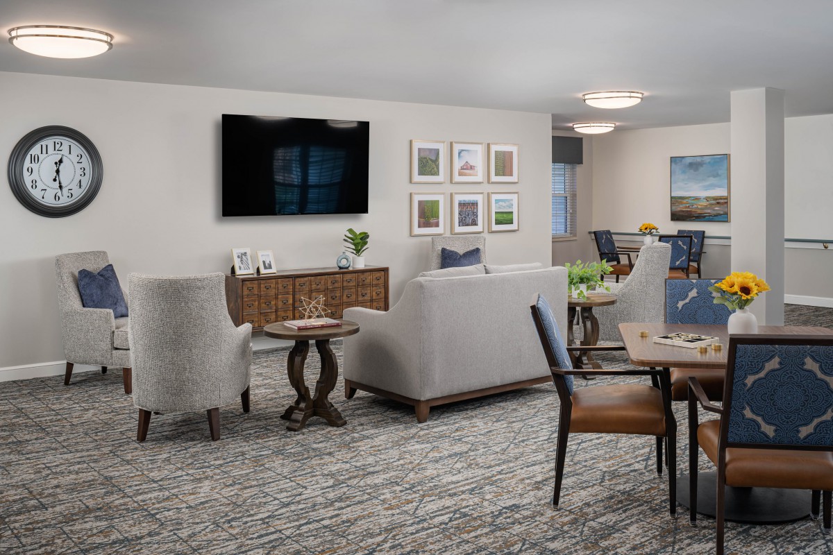 A modern living room with comfortable seating, decorative elements, and a mounted television.