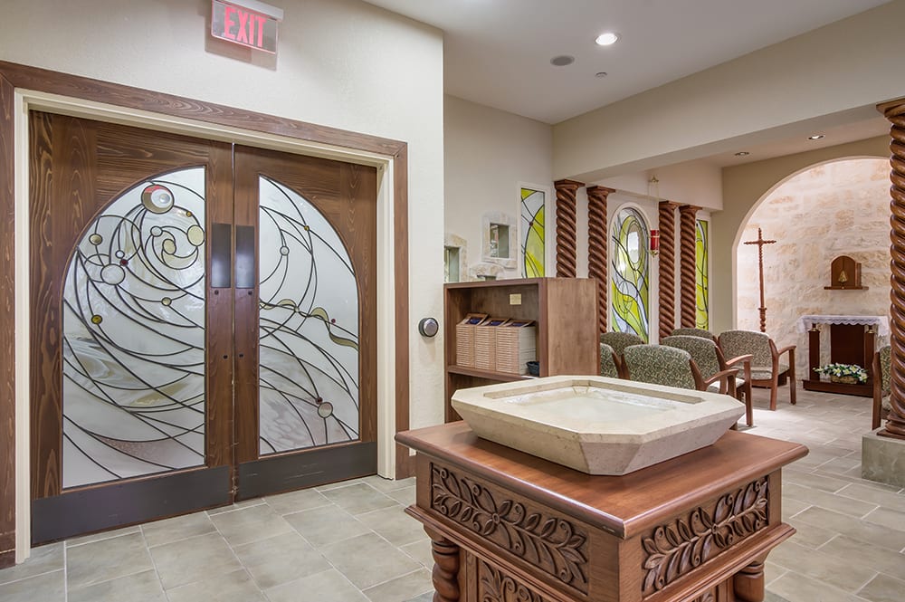 A tastefully designed interior with decorative wooden and glass elements, featuring a waiting area and intricate woodwork.