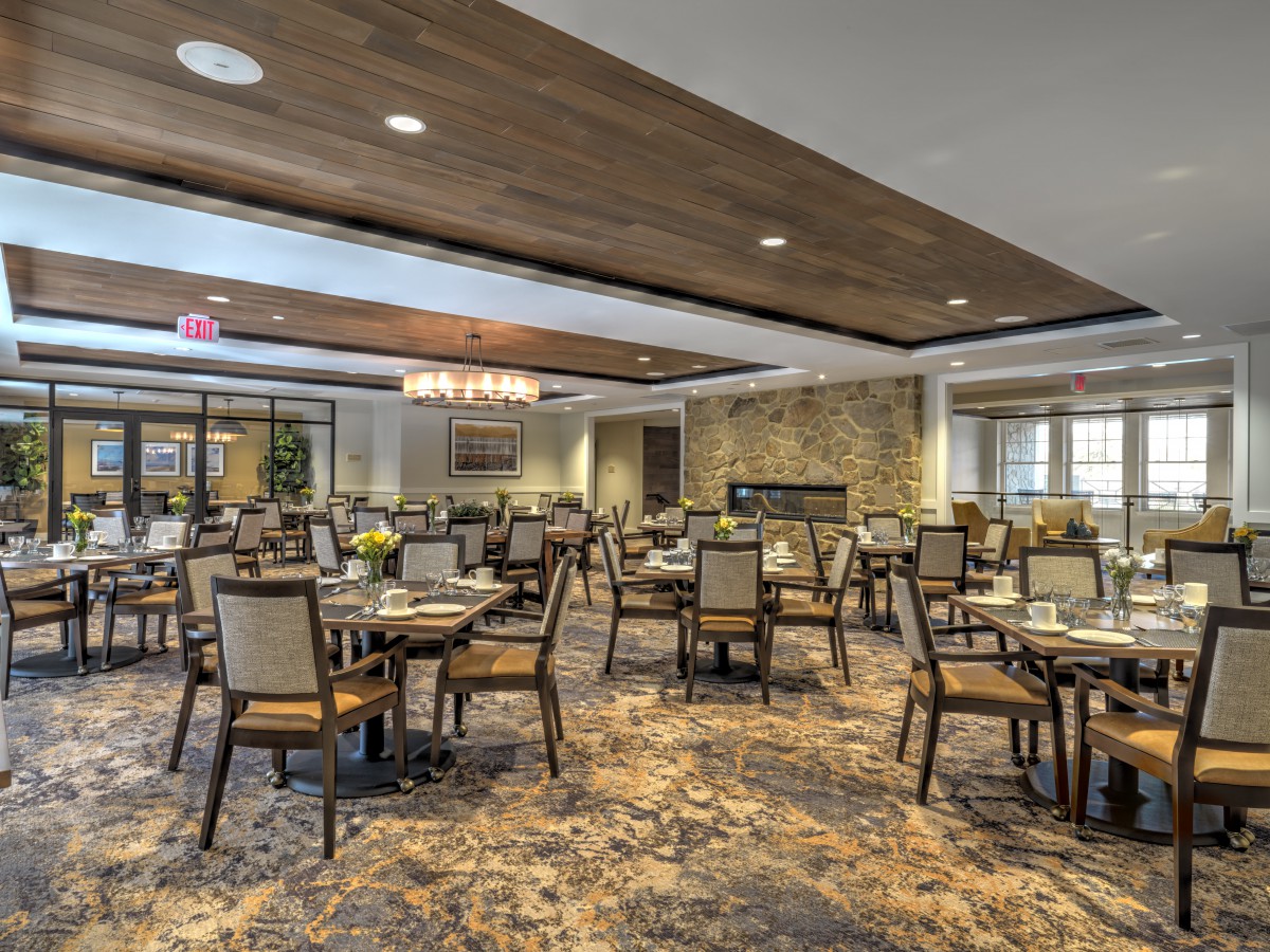 A spacious and elegantly decorated dining area with neatly arranged tables and chairs.