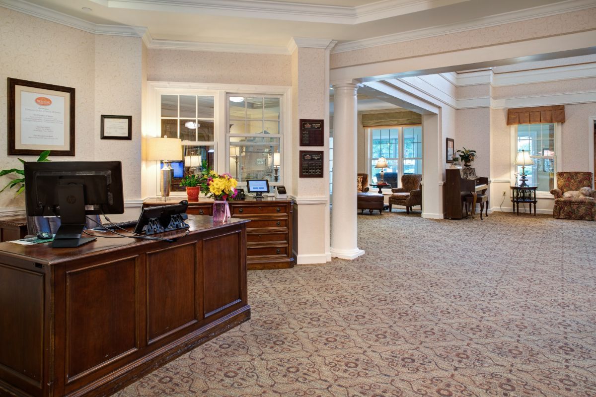 A welcoming reception area with a wooden front desk and cozy seating in the background.