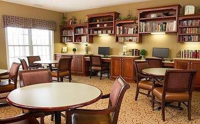 A cozy library with computers, bookshelves, and tables for study or reading.