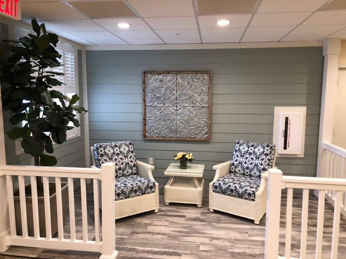 A cozy indoor seating area with two patterned armchairs, a small table, and decorative artwork on the wall.