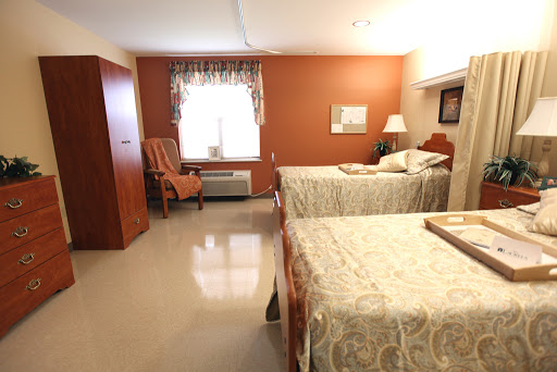 A spacious and inviting bedroom featuring two beds, a comfortable chair, and warm-colored walls.