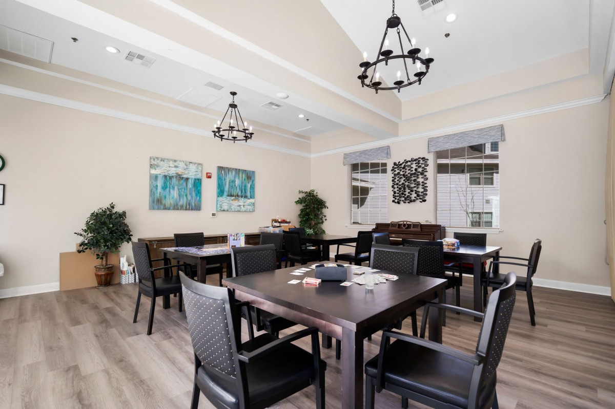 A well-lit dining area with elegant chandeliers, modern furniture, and stylish decor.