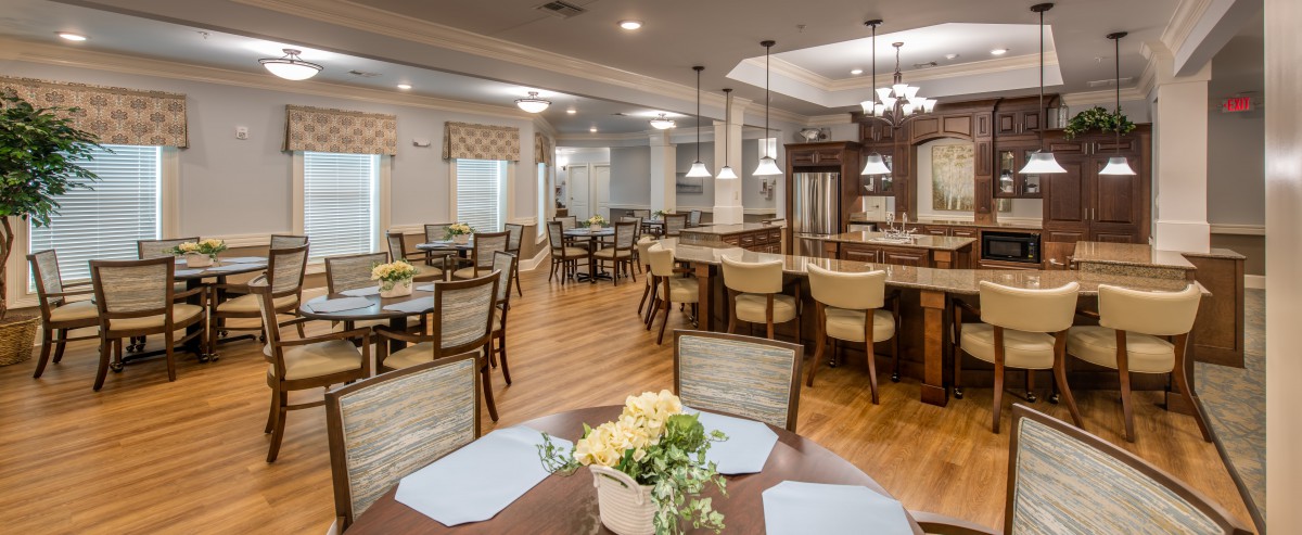 A well-lit and elegantly furnished dining area with wooden floors and comfortable seating.
