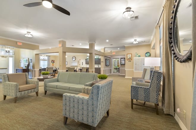 A spacious and well-decorated living room with comfortable seating and modern lighting.