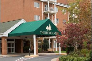 The entrance of a building with green awning labeled 'The Highlands'.