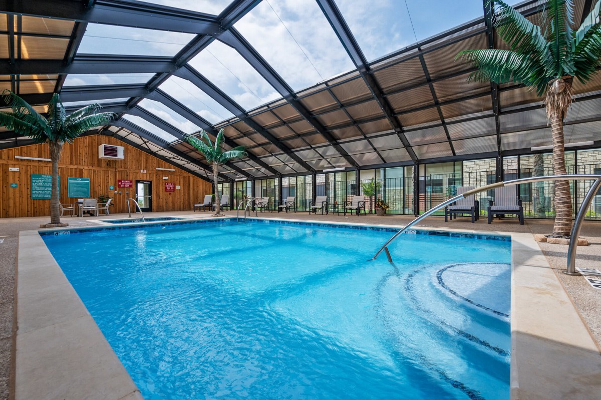 An inviting indoor swimming pool with a glass roof, perfect for relaxation and leisure activities.