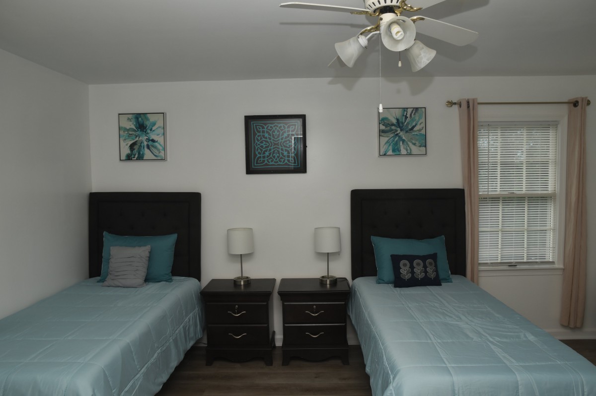 A neatly arranged bedroom with twin beds and matching decor.