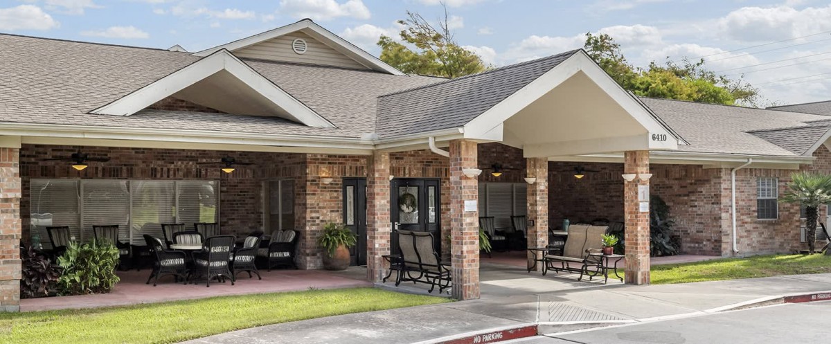 A cozy residential building with a sheltered porch and outdoor seating.