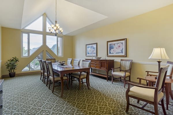 A well-decorated dining room with a wooden table, chairs, and artwork on the walls.