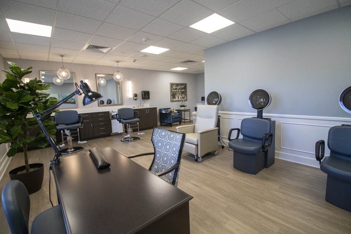 A modern salon interior featuring styling stations and comfortable seating.