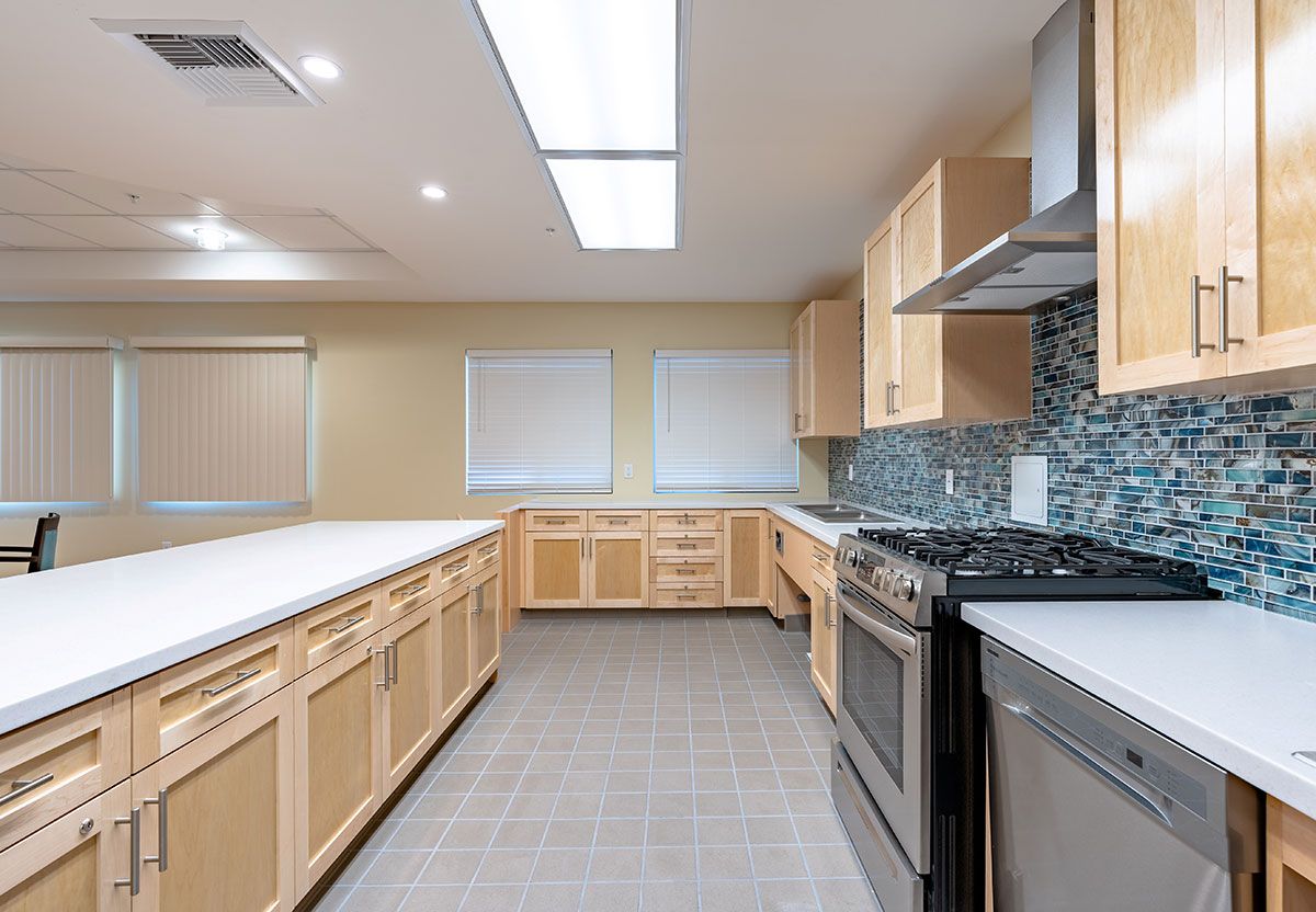 A spacious and modern kitchen with stainless steel appliances and wood cabinetry.