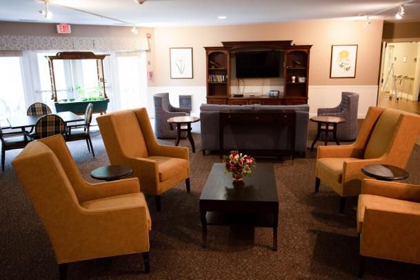 A cozy living room with armchairs, a coffee table, and a television.