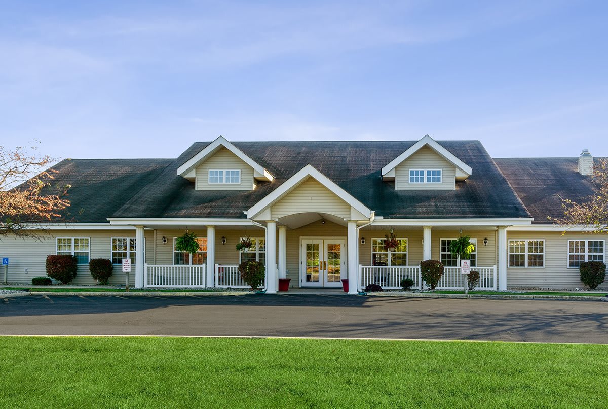 A spacious residential house with a large front porch and well-maintained lawn.